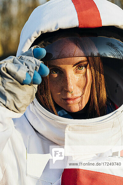 Weibliche Forscherin mit Weltraumhelm starrt auf einen sonnigen Tag