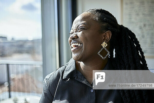 Cheerful businesswoman laughing at office