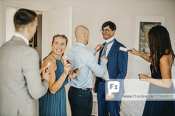 Hübscher Bräutigam mit Freunden  die sich während der Hochzeit anziehen