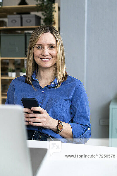 Smiling blond woman using mobile phone