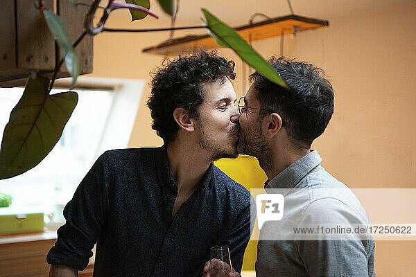 Schwules Paar küsst sich zu Hause