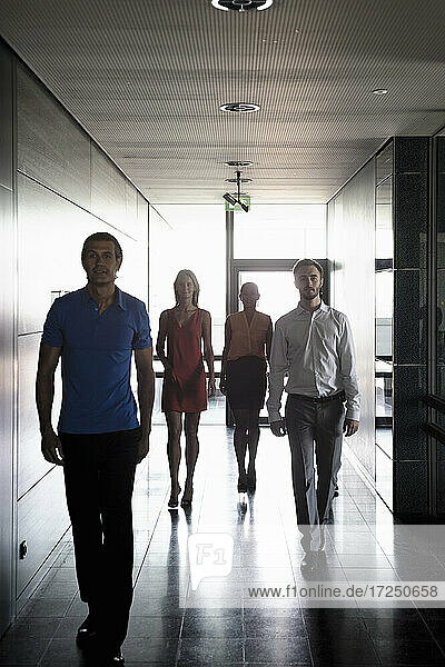 Männliche und weibliche Unternehmer gehen im Korridor eines Büros spazieren