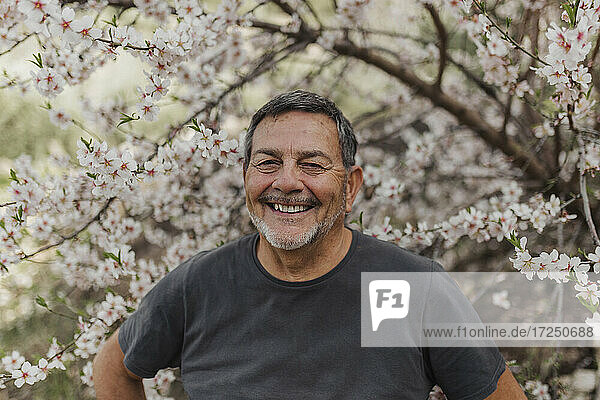 Lächelnder älterer Mann vor einem Baum