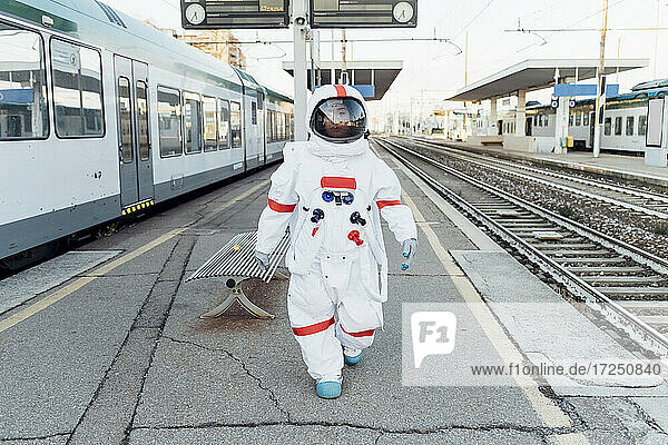 Astronautin im Raumanzug auf dem Bahnhof