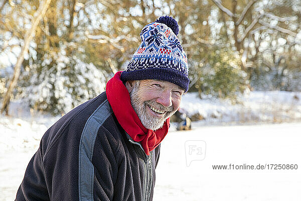 Lächelnder älterer Mann mit Strickmütze im Winter
