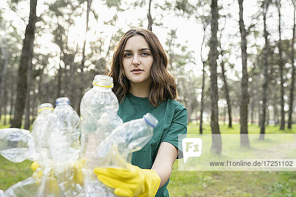 Junger Umweltschützer sammelt Plastikflaschen im Wald