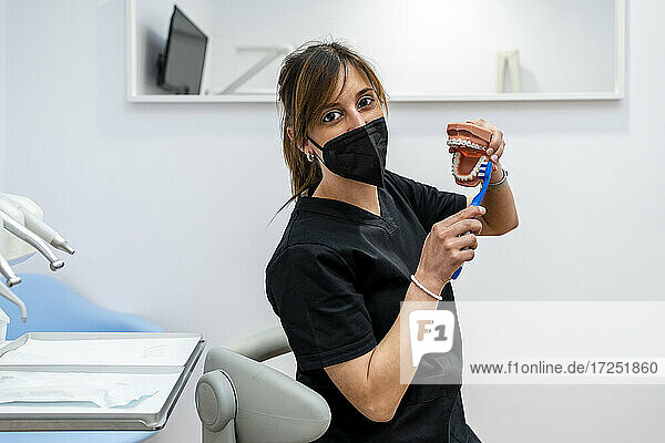 Zahnärztin beim Putzen von Zahnschimmel während der Pandemie in einer medizinischen Klinik
