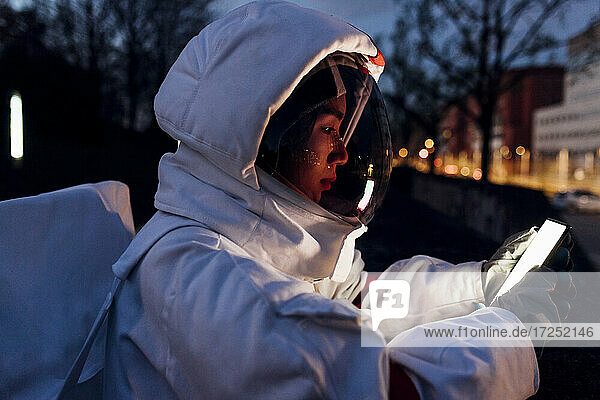 Junge Astronautin benutzt nachts ein Mobiltelefon