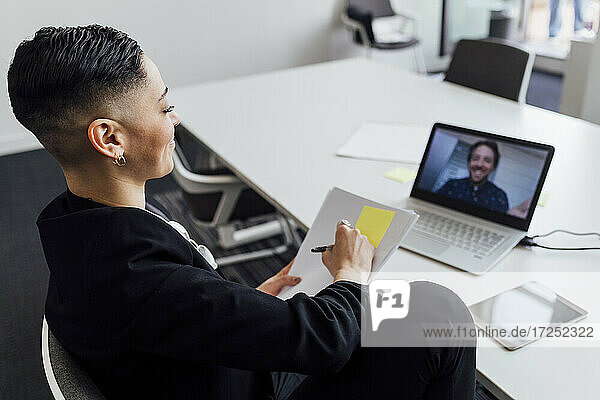 Female entrepreneur planning business strategy through video call on laptop at office