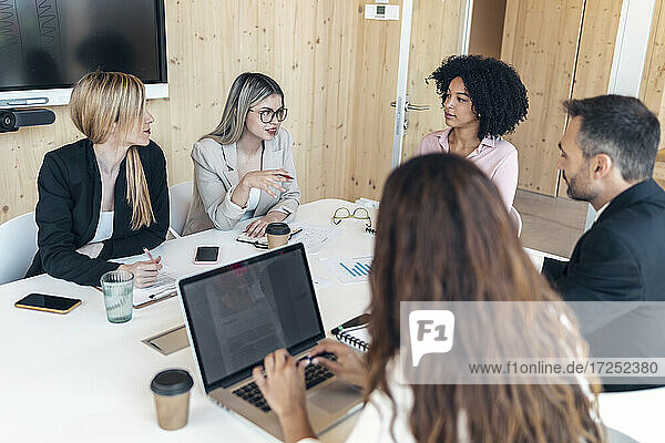 Männliche und weibliche Mitarbeiter diskutieren während einer Besprechung im Büro