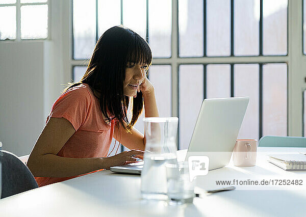 Geschäftsfrau mit Laptop auf dem Tisch bei der Arbeit im Heimbüro
