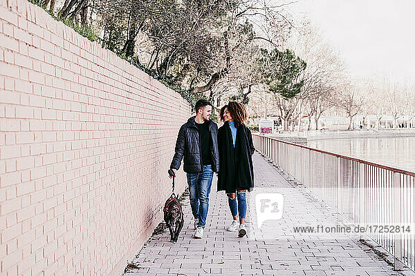Junges Paar mit Hund auf dem Fußweg