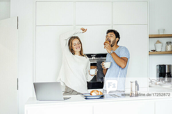Girlfriend and boyfriend enjoying breakfast in kitchen at home