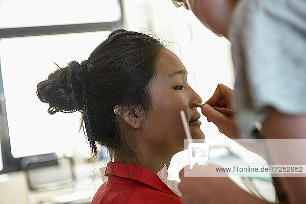 Make-up-Künstlerin trägt Make-up auf ein Modell im Studio auf