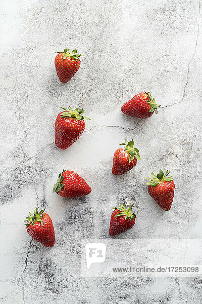 Frische Erdbeeren liegen auf weißem Marmor