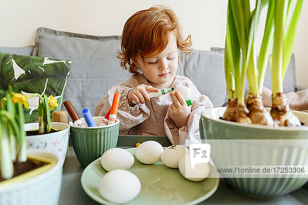 Mädchen beim Eierfärben zu Ostern zu Hause