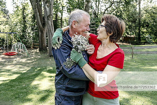 Affectionate senior couple embracing in backyard