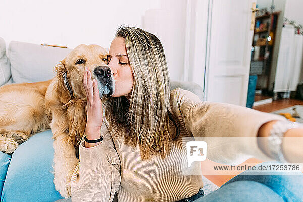 Italien  Junge Frau küsst Hund zu Hause