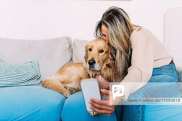 Italien  Junge Frau macht Selfie mit Hund zu Hause