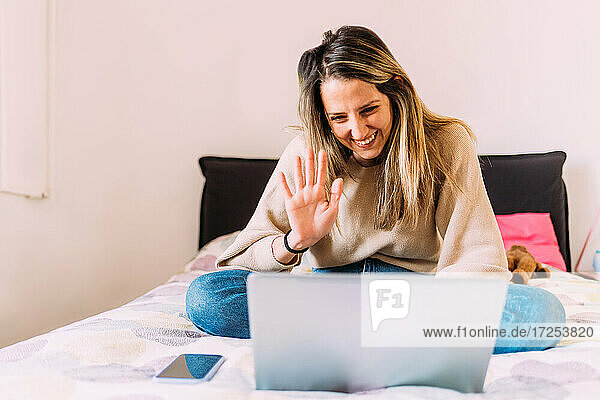 Italien  Junge Frau mit Laptop auf dem Bett