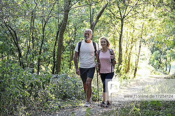 Smiling mature couple hiking together in forest