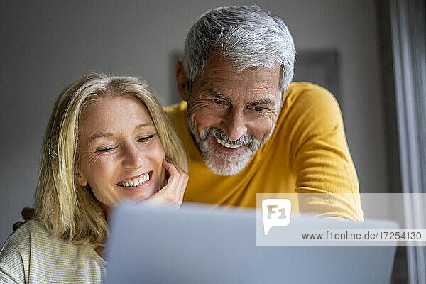 Lächelndes reifes Paar mit Laptop