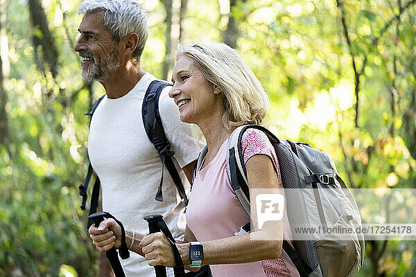 Lächelndes reifes Paar wandert zusammen im Wald