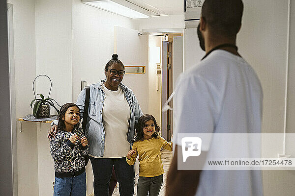 Glückliche Mutter mit Töchtern beim Besuch einer medizinischen Klinik