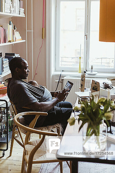 Männlicher Unternehmer  der ein digitales Tablet im Home-Office benutzt