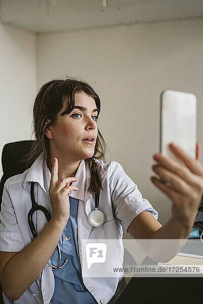 Weiblicher Arzt berät Patient über Videoanruf in medizinischer Klinik