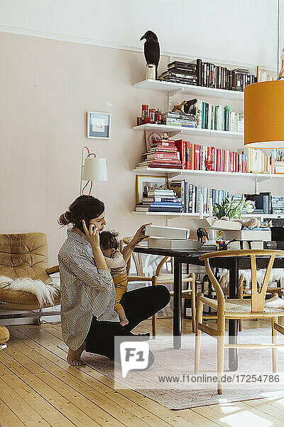 Weibliche Unternehmerin spricht durch Smartphone während der Arbeit im Home-Office