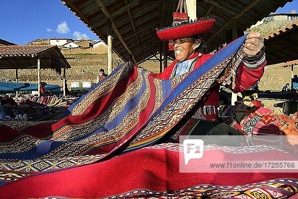 Indigenous old woman selling colorful blankets at the weekly market market  Chinchero  Cusco region  Urubamba province  Peru  South America