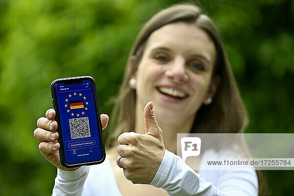 Symbofoto Impfprivileg  junge Frau hält Smartphone mit digitalem europäischen Impfpass für deutsche Staatsbürger  mit QR-Code  Corona-Krise  Deutschland  Europa