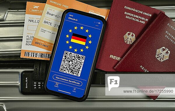 Symbolfoto Impfprivileg  auf Koffer liegen Smartphone mit digitalem europäischen Impfpass mit QR-Code  Reisepässe  Bordkarten für Flugreise  Corona-Krise  Deutschland  Europa