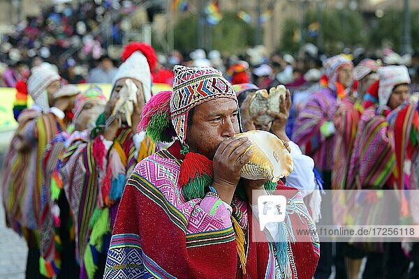Indigenous man blows conch shell during parade on eve of Inti Raymi  festival of the sun