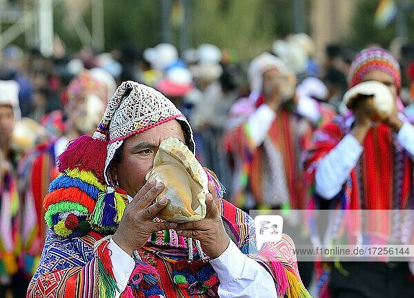 Indigenous man blows conch shell during parade on eve of Inti Raymi  festival of the sun