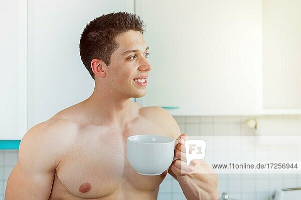 Bodybuilder junger Mann nachdenken Zukunft Textfreiraum Copyspace trinkt trinken Kaffee in der Küche morgens Morgen lachen in Deutschland