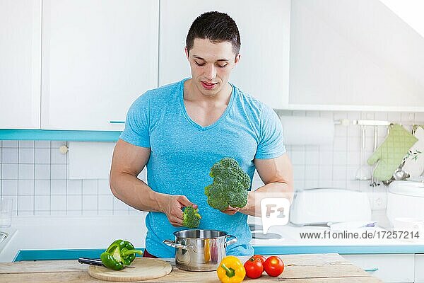 Junger Mann kochen Essen zubereiten Gemüse Mittagessen in der Küche gesunde Ernährung gesund in Deutschland