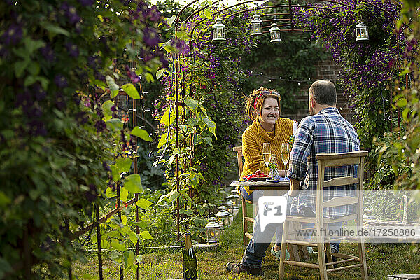 Glückliches Paar genießt Champagner im idyllischen Sommergarten