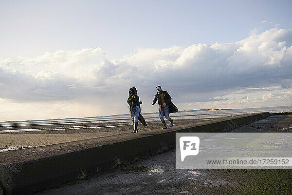 Paar läuft auf Ozean Strand Steg