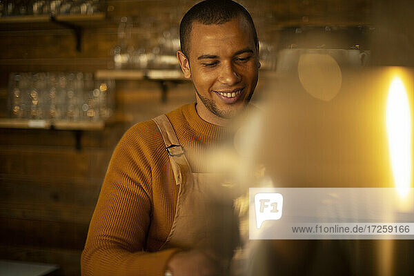 Lächelnde männliche Barista bereitet Kaffee im Café