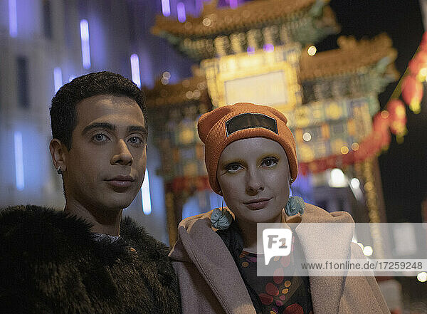 Portrait cool young couple at Chinatown gate at night  London  UK