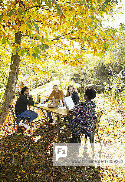 Geschäftsleute mit Papierkram Sitzung am Tisch in sonnigen Herbst Park