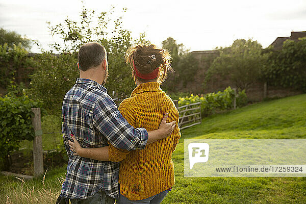 Glückliches Paar umarmt in sonnigen Sommergarten