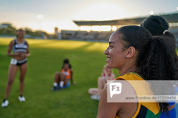 Lächelnde weibliche Leichtathletin im Stadion Gras