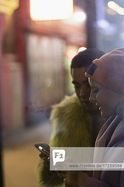 Stylish junges Paar mit Smartphones auf städtischen Bürgersteig