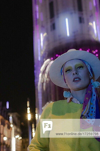 Porträt kühle modische Frau in Fedora unter Stadt Gebäude in der Nacht