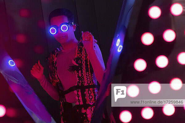 Porträt modischer junger Mann mit futuristischer Neonbrille im Nachtclub