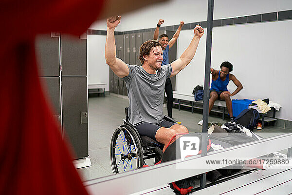 Confident happy wheelchair athlete cheering in locker room mirror