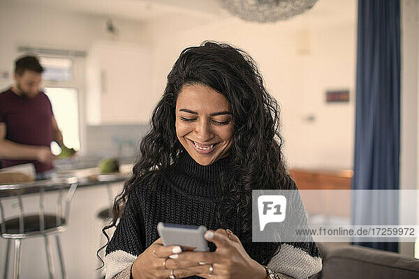 Glückliche Frau verwendet Smartphone zu Hause
